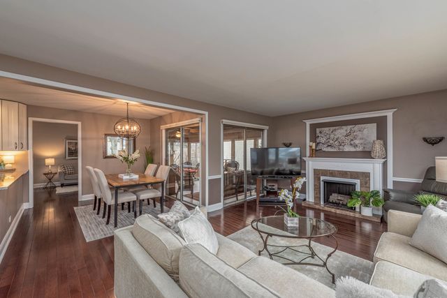 a living room with furniture a fireplace and a floor to ceiling window