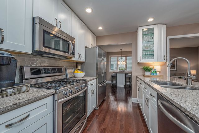 a kitchen with stainless steel appliances granite countertop a stove and a sink
