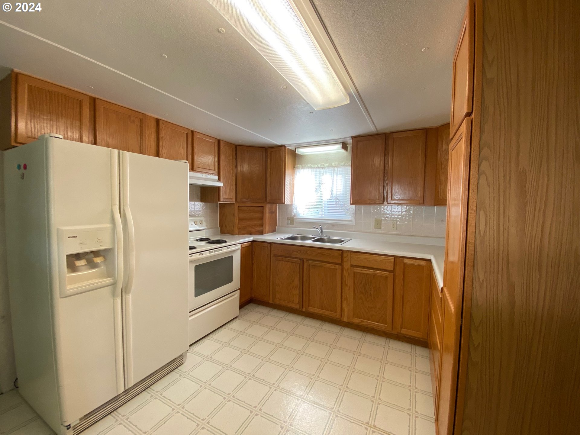 3950 Coburg Road, Unit 82 Eugene, OR 97408 - Photo 8 of 22 a kitchen with granite countertop a refrigerator and a sink