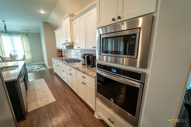a kitchen with stainless steel appliances kitchen island wooden cabinets and stove