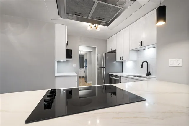 a kitchen with stainless steel appliances granite countertop a sink stove and refrigerator