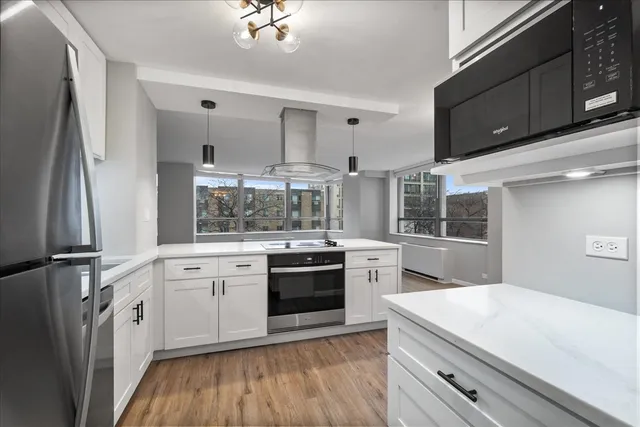 a kitchen with stainless steel appliances kitchen island granite countertop a stove a sink and a refrigerator