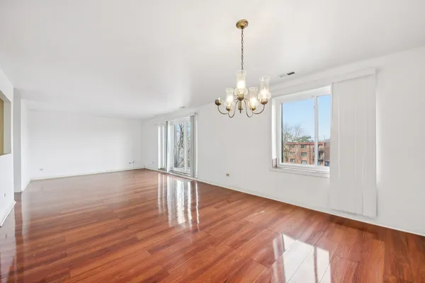 a view of a room with wooden floor chandelier and entryway