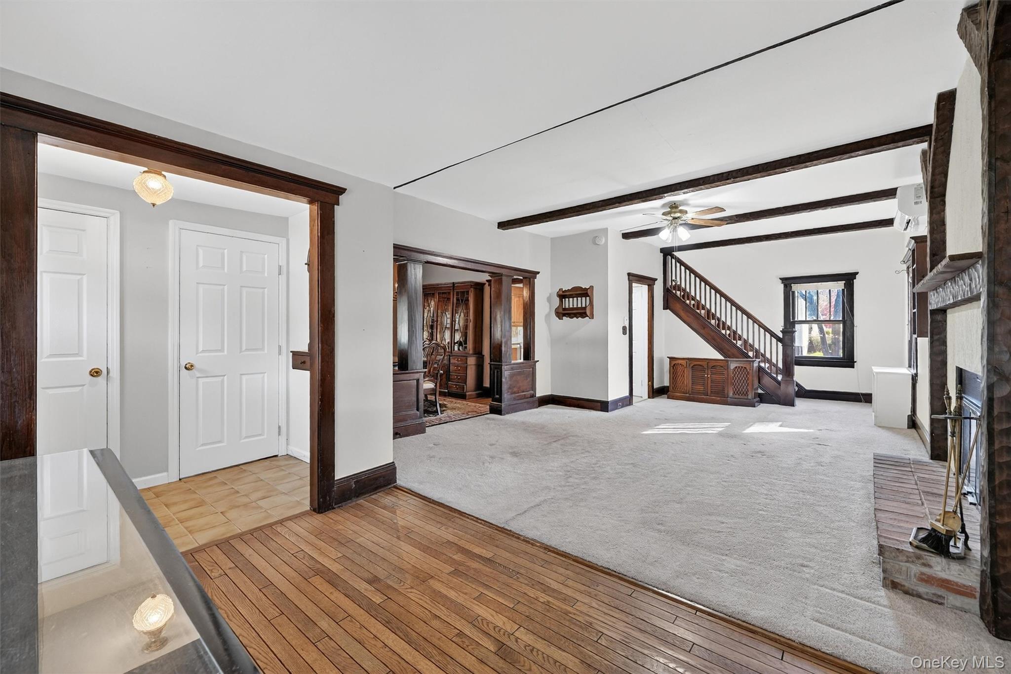 165 Wayne Avenue Suffern, NY 10901 - Photo 11 of 38 Unfurnished living room with beamed ceiling, light wood-style floors, a fireplace, ceiling fan, and stairway