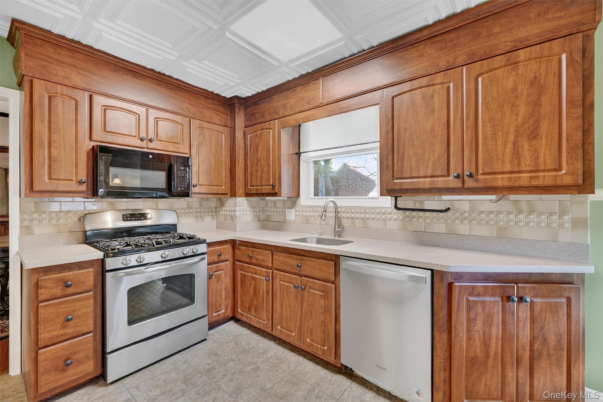 165 Wayne Avenue Suffern, NY 10901 - Photo 21 of 38 Kitchen with brown cabinets, appliances with stainless steel finishes, tasteful backsplash, and an ornate ceiling