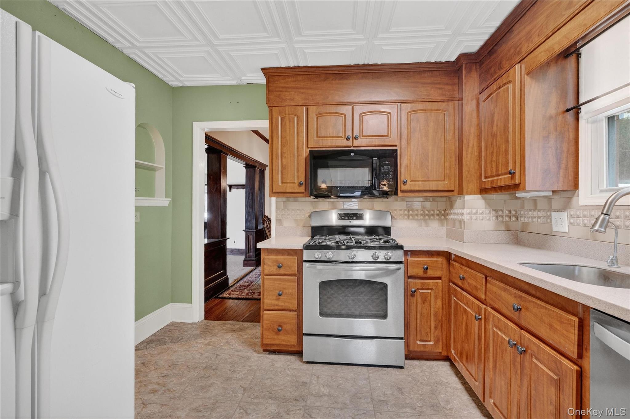 165 Wayne Avenue Suffern, NY 10901 - Photo 23 of 38 Kitchen featuring stainless steel appliances, brown cabinets, healthy amount of natural light, and an ornate ceiling