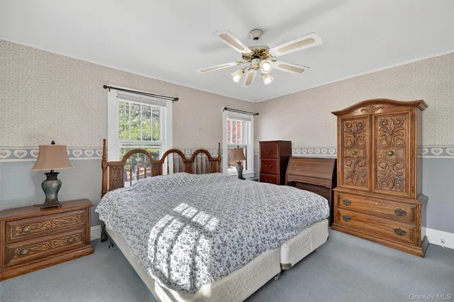 a bedroom with a bed and dresser with chandelier