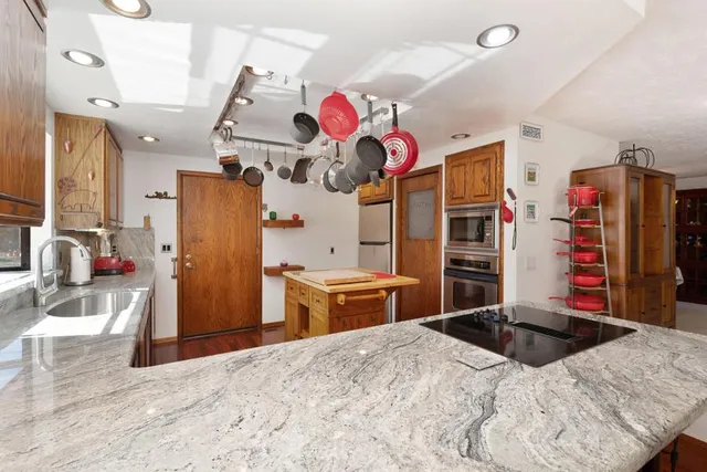 a bathroom with a granite countertop sink a mirror and shower