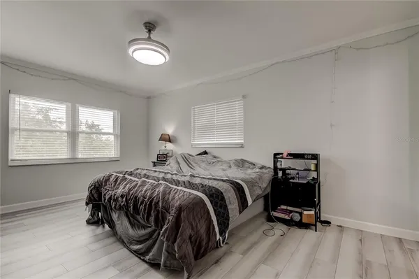 a bedroom with a bed and wooden floor