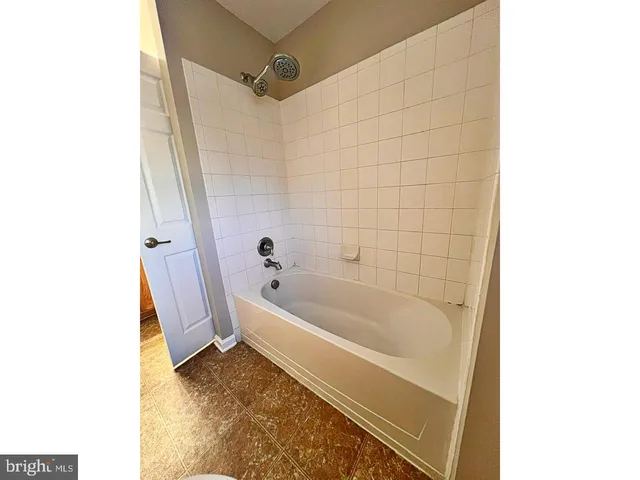 a bathroom with a tub shower and sink