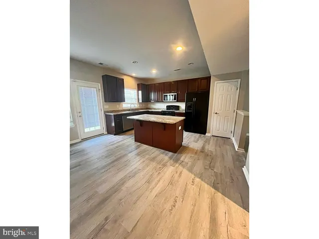 a kitchen with kitchen island stainless steel appliances a sink and a counter top