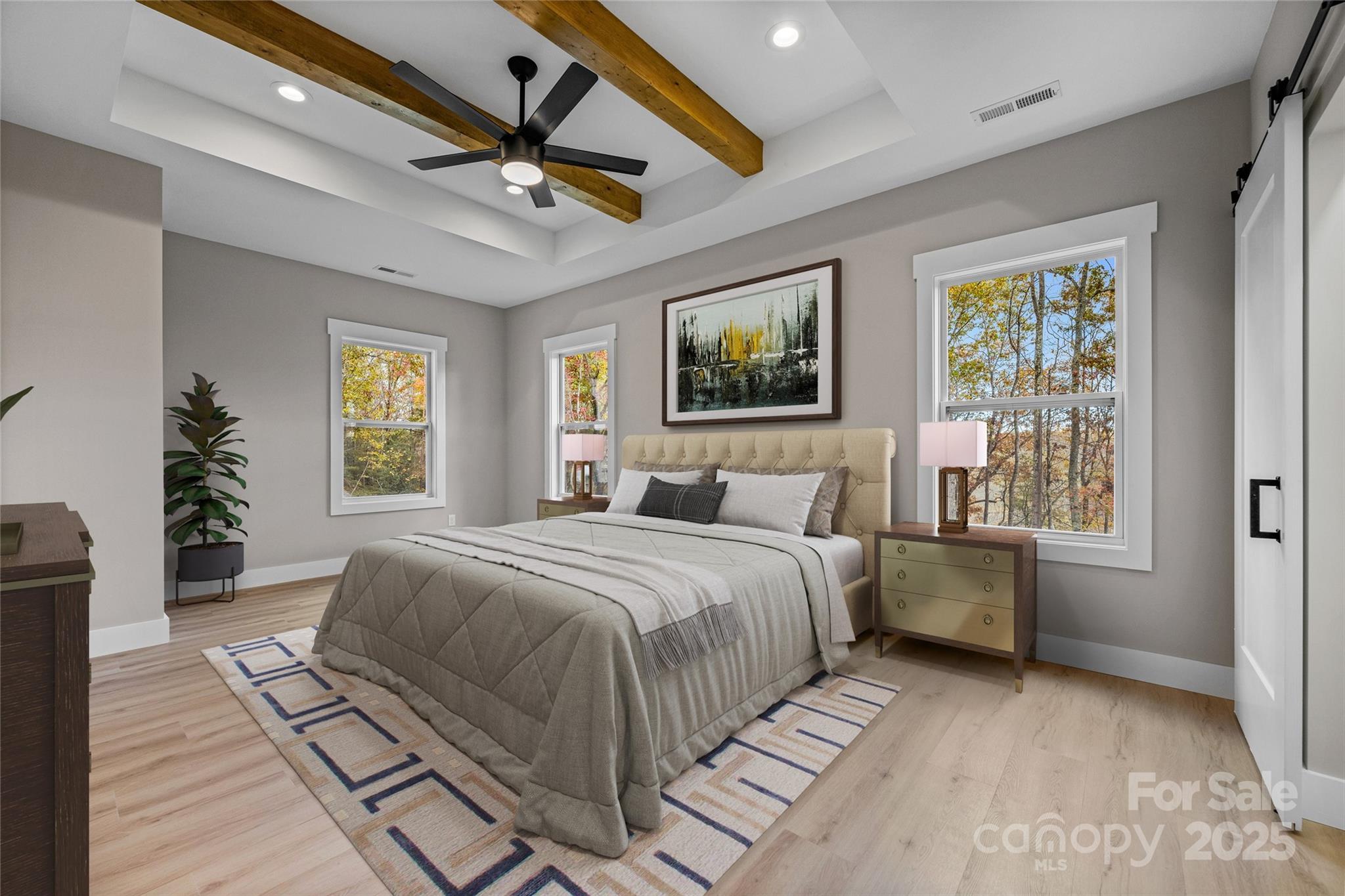 446 Old Buckeye Cove Road Swannanoa, NC 28778 - Photo 30 of 48 a spacious bedroom with a large bed a chandelier and windows