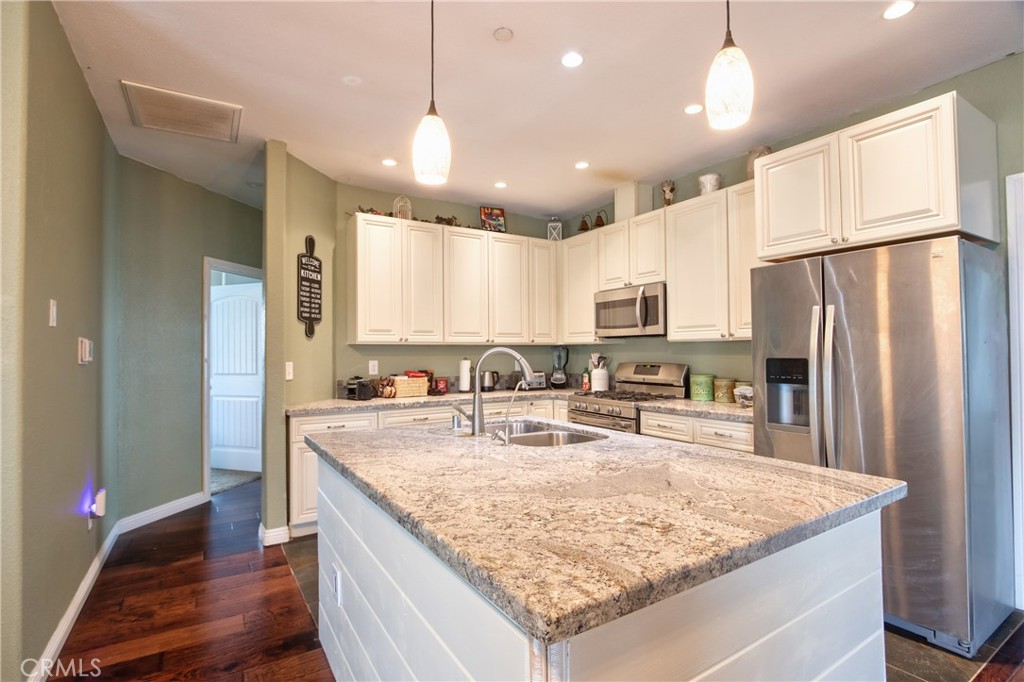 40105 Voyager Road Hemet, CA 92544 - Photo 6 of 27 a kitchen with stainless steel appliances granite countertop a refrigerator a sink and a stove