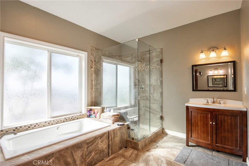 40105 Voyager Road Hemet, CA 92544 - Photo 8 of 27 a spacious bathroom with a bathtub a sink and a mirror