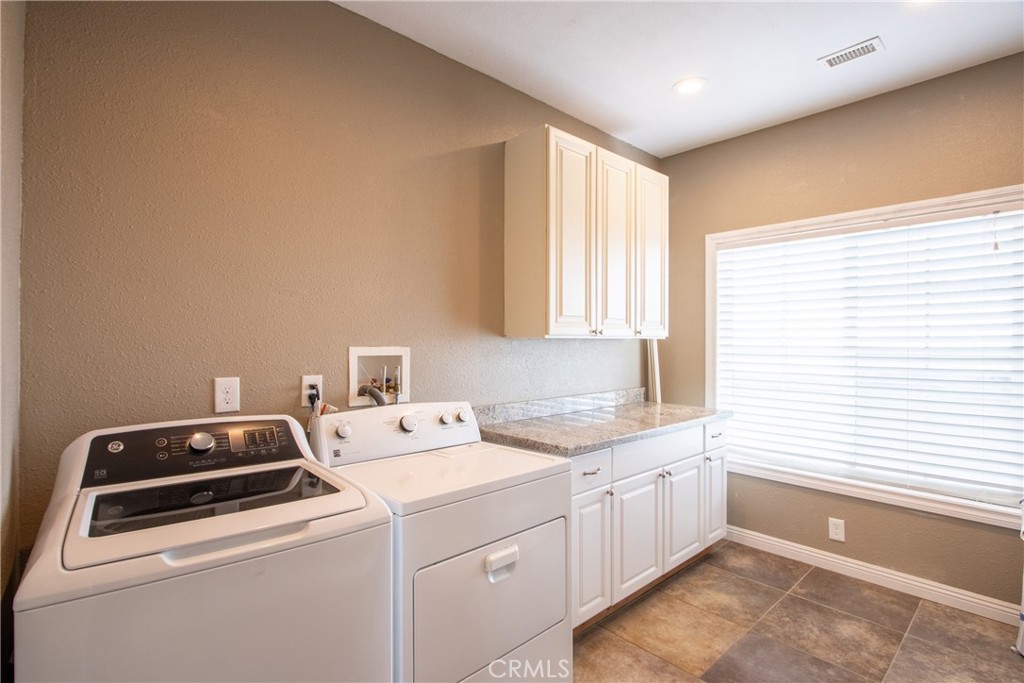 40105 Voyager Road Hemet, CA 92544 - Photo 10 of 27 a view of a kitchen with a stove top oven a sink a counter space and a window