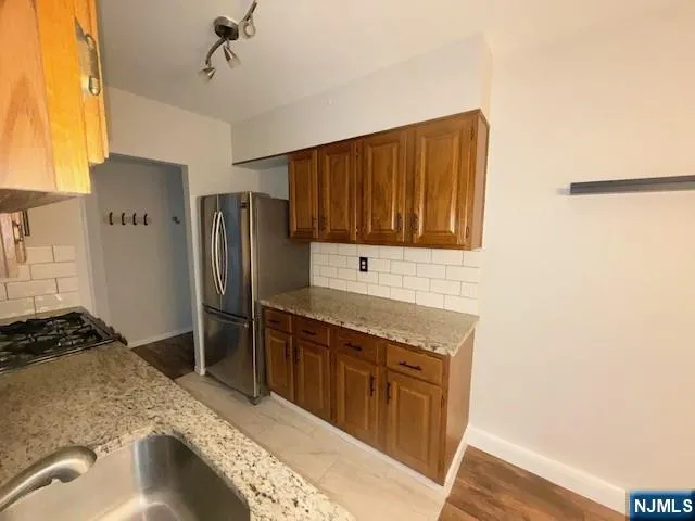 a kitchen with stainless steel appliances granite countertop a refrigerator and a stove top oven