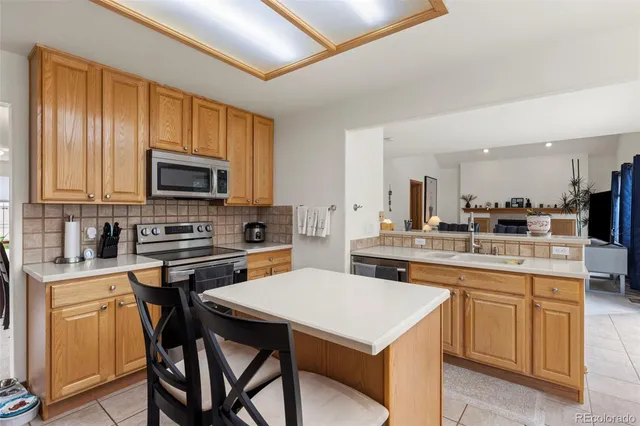 a kitchen with a stove a sink a dining table and chairs