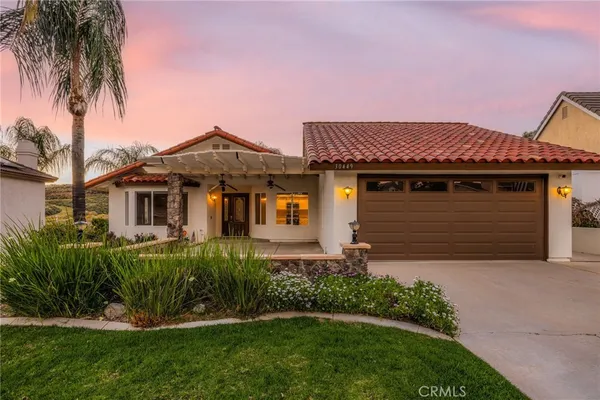 a front view of a house with a garden and plants