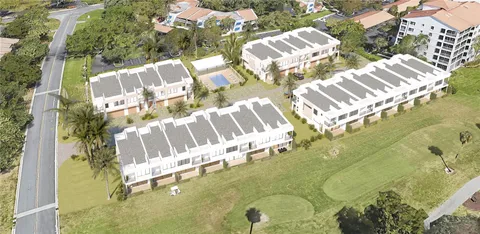 a view of a white building with a yard