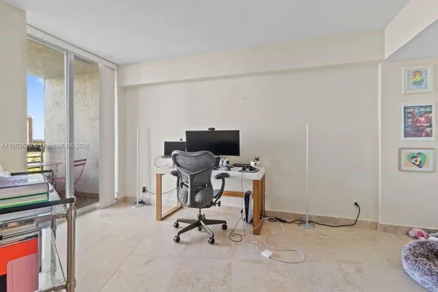 a view of a workspace with furniture and a window