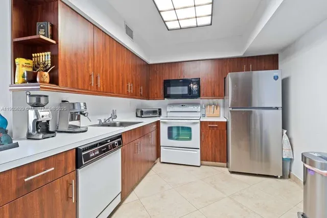 a kitchen with stainless steel appliances granite countertop a refrigerator sink and stove