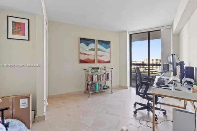 a view of a workspace with furniture and a window