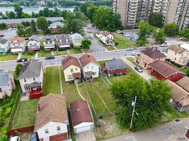 an aerial view of residential houses with outdoor space and city view