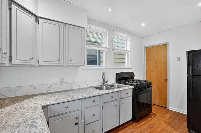 a kitchen with granite countertop a sink stainless steel appliances and cabinets