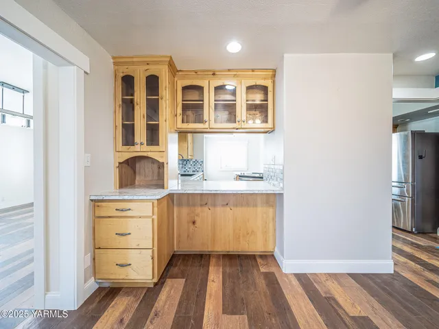 a hallway with cabinets and wooden floor