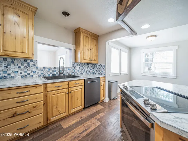 a kitchen with a stove a sink and a wooden cabinets