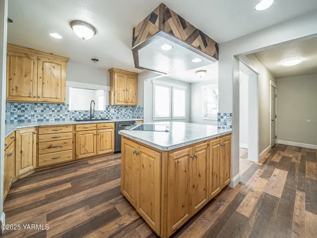 a large white kitchen with a large window a sink and stainless steel appliances