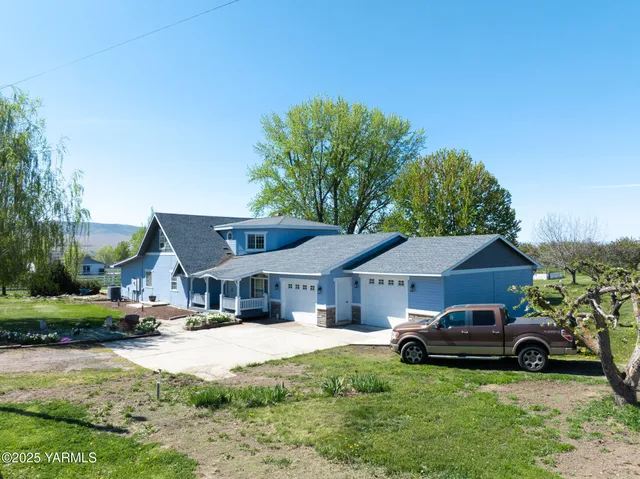 a front view of a house with a garden and trees