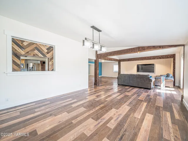 a view of spacious bedroom with wooden floor and ceiling fan