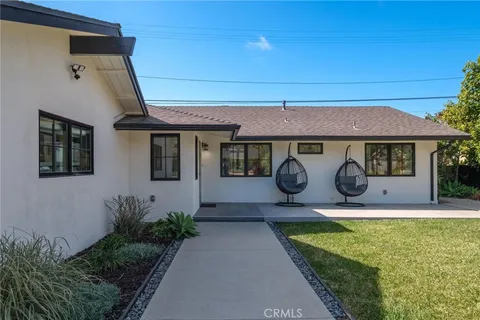 a house view with swimming pool in front of it