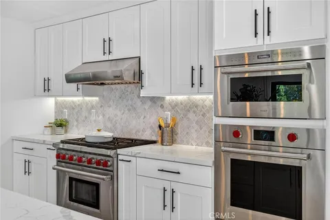a kitchen with stainless steel appliances granite countertop a stove and a microwave