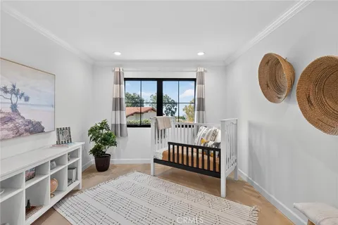 a view of a bedroom with wooden floor and a potted plant