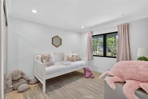 a spacious bedroom with a bed and wooden floor