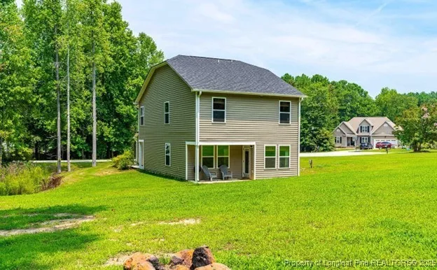 a view of a house with a yard and sitting area