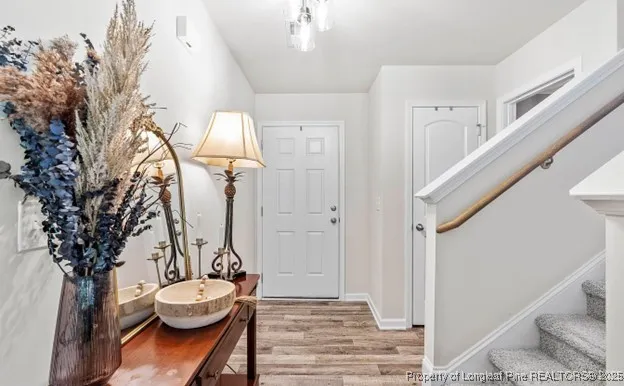 a view of a hallway with wooden floor and staircase