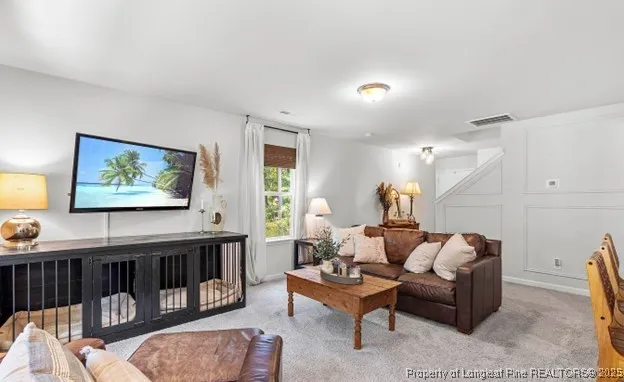 a living room with furniture and a painting on the wall