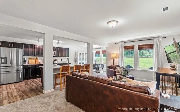 a kitchen with sink refrigerator dining table and chairs