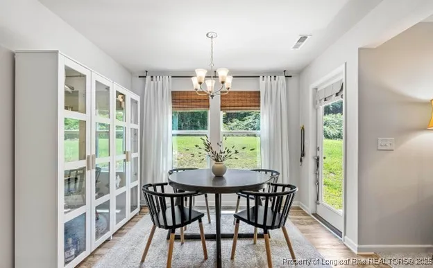 a dining room with furniture a chandelier and wooden floor