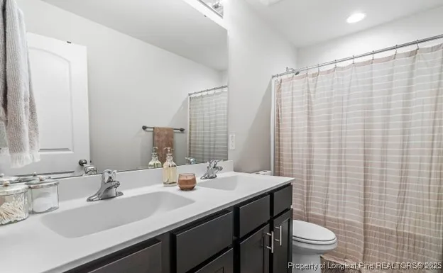 a bathroom with a sink a toilet and shower curtain
