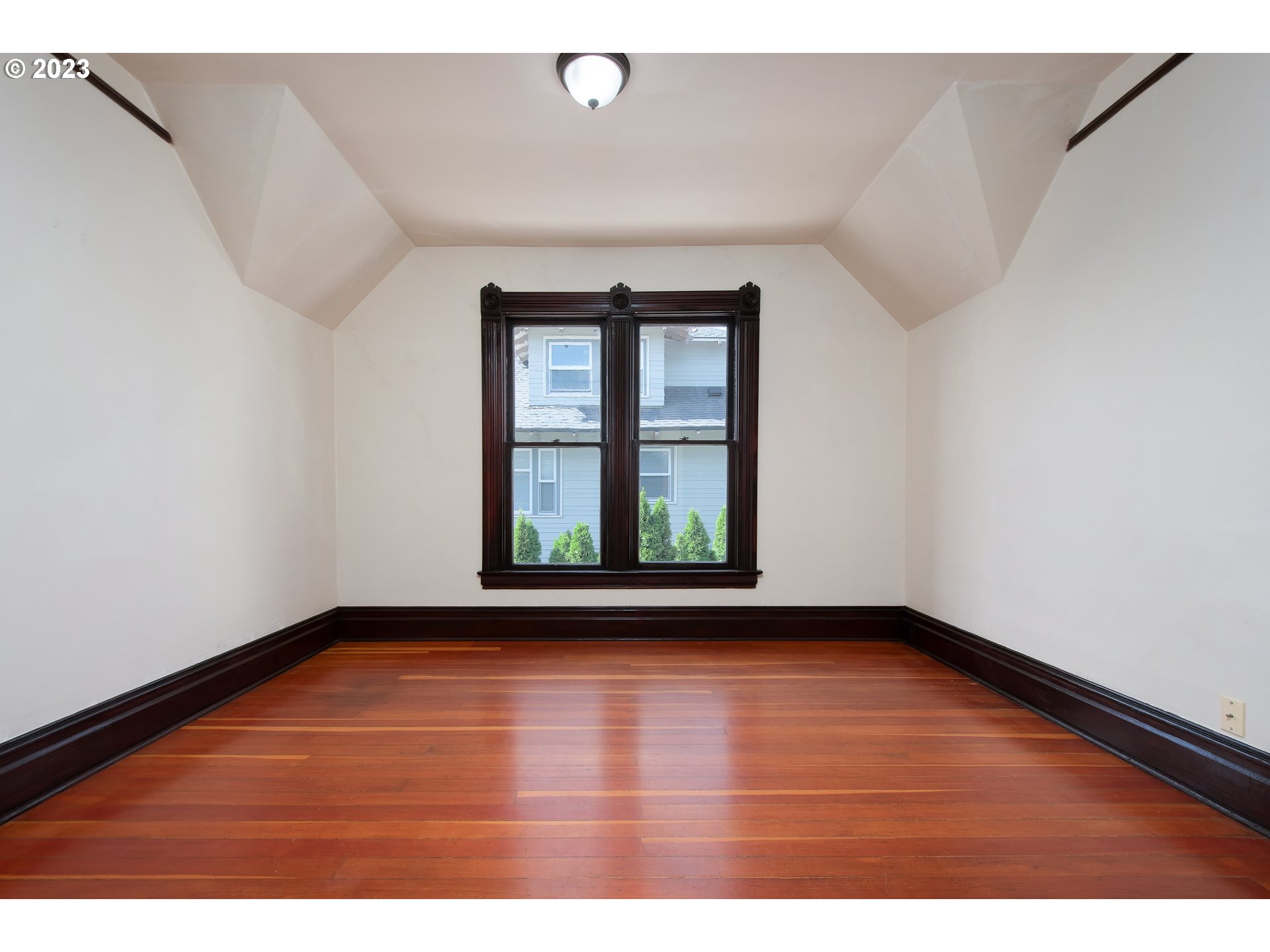 3519 Southeast Morrison Street Portland, OR 97214 - Photo 20 of 43 a view of an empty room with a window and wooden floor