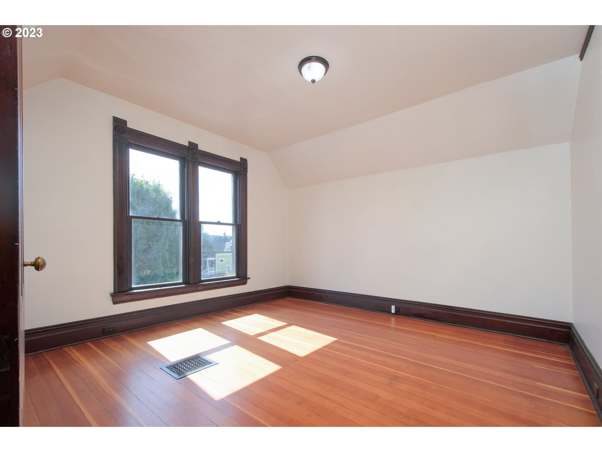 3519 Southeast Morrison Street Portland, OR 97214 - Photo 21 of 43 a view of an empty room with wooden floor and a window