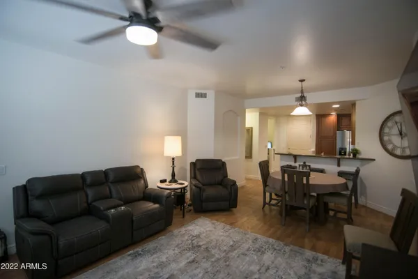 a living room with furniture a clock on wall and a window