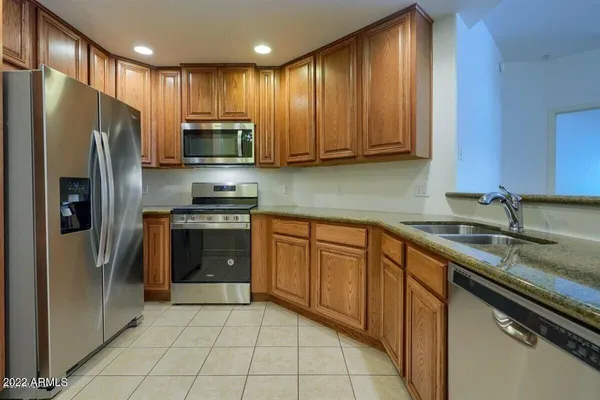 a kitchen with stainless steel appliances granite countertop a refrigerator sink and cabinets