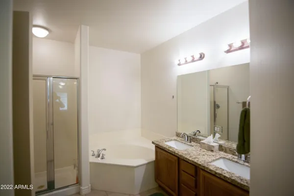 a bathroom with a granite countertop tub sink and mirror