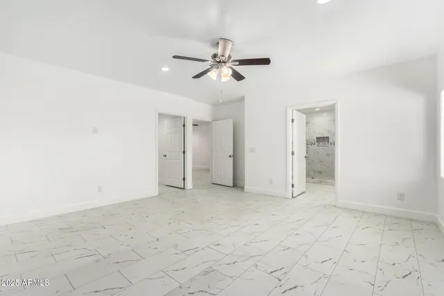 an empty room with a ceiling fan and carpet