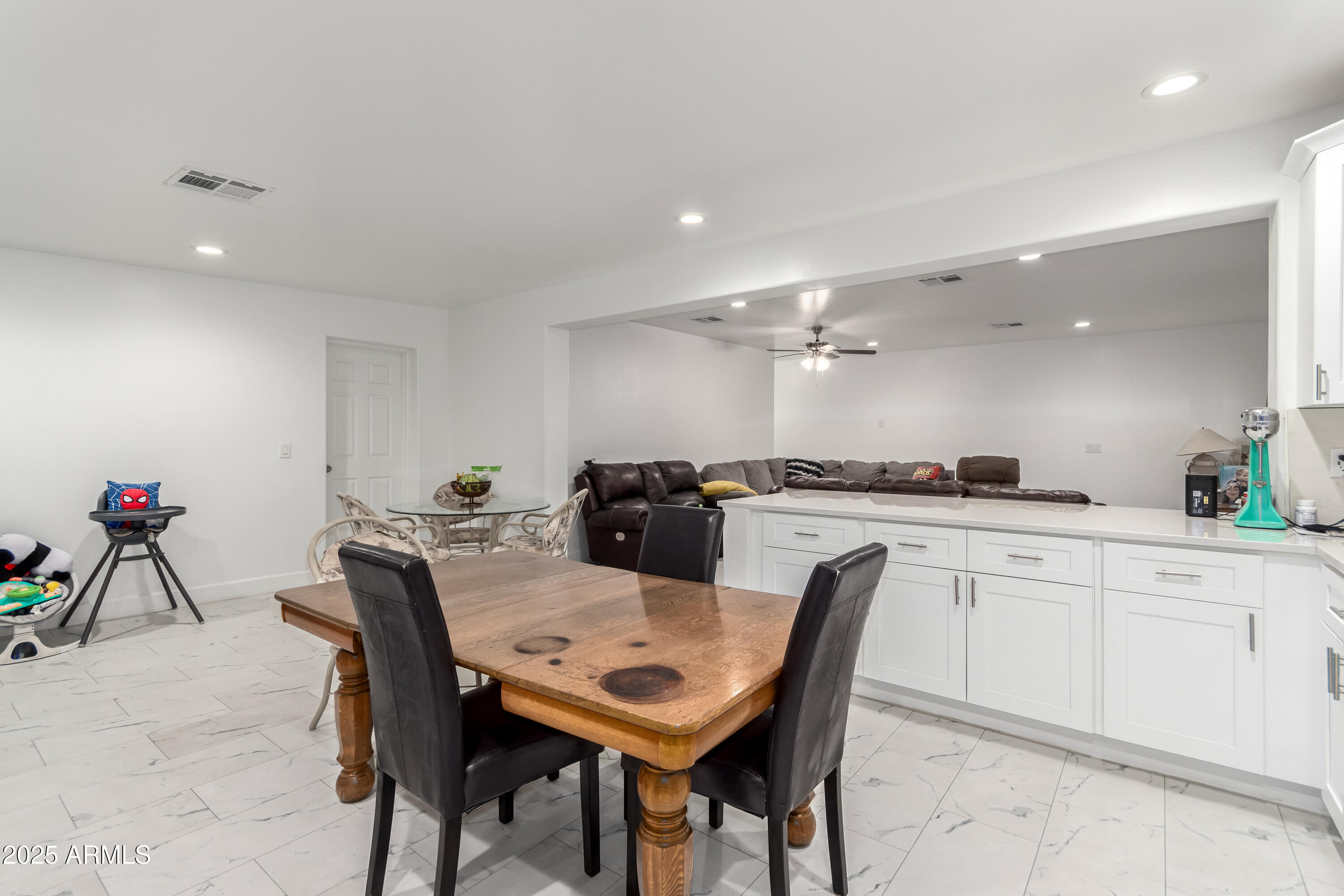 15640 North Verde Street Surprise, AZ 85378 - Photo 32 of 56 a kitchen with a dining table chairs and white cabinets